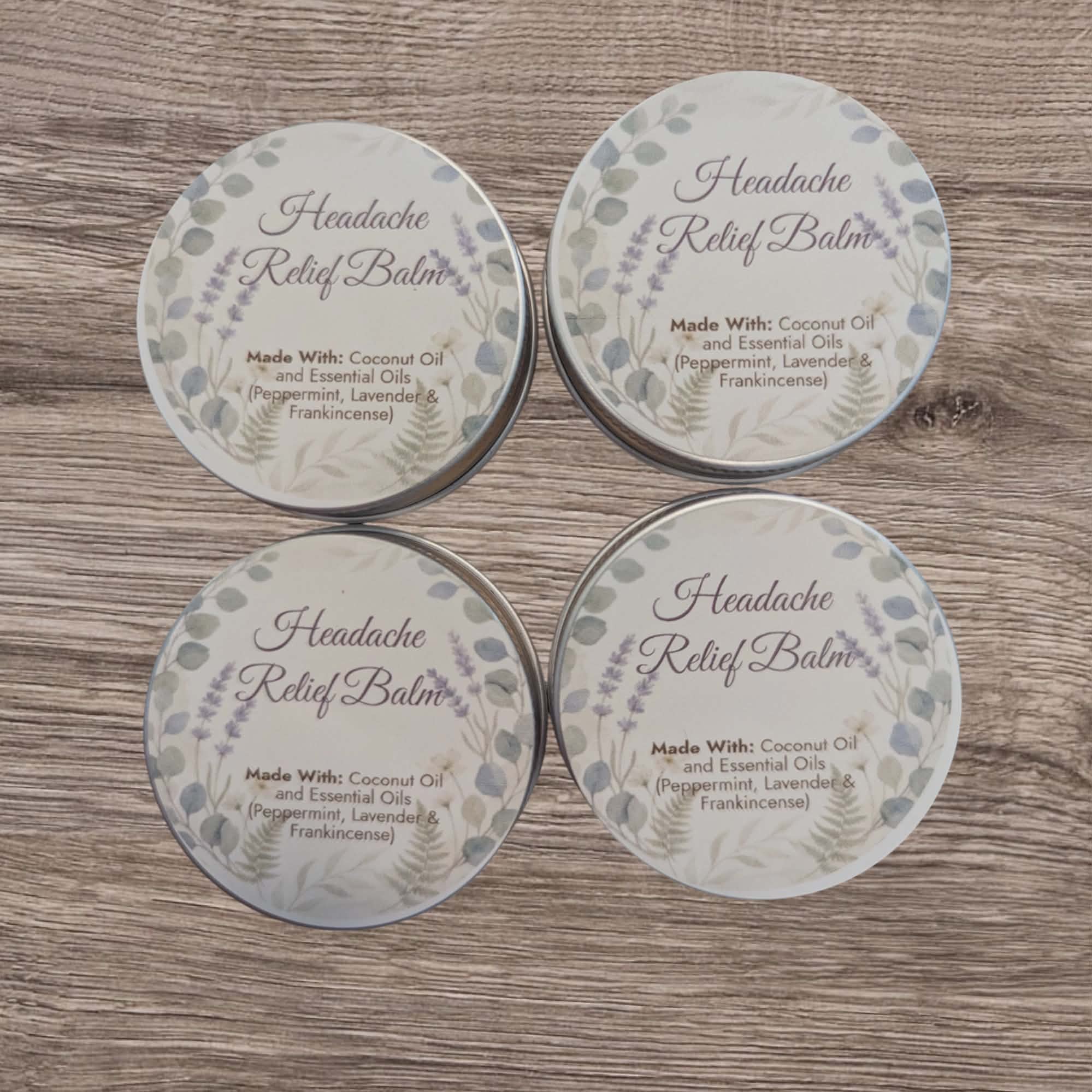 Four tins of Headache Relief Balm on a wooden surface