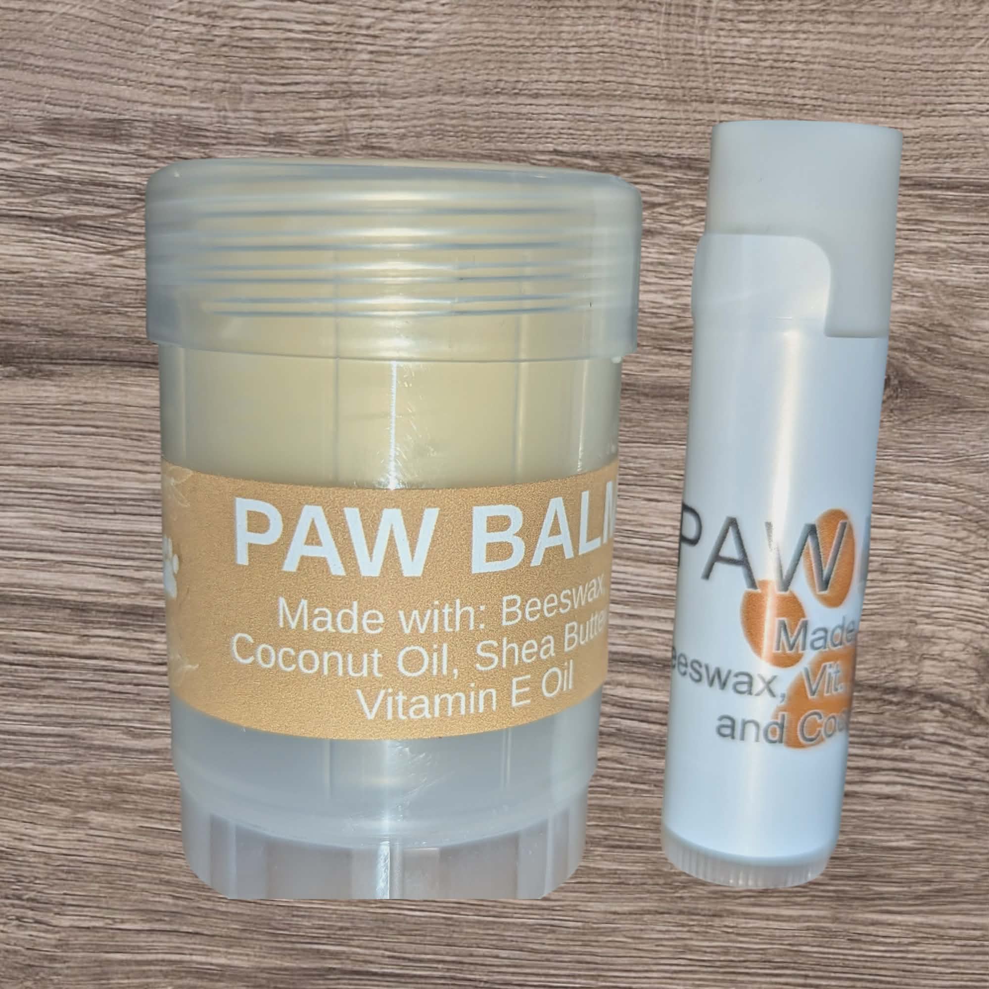 Two paw balms on a wooden surface, one in a jar and one in a stick form.