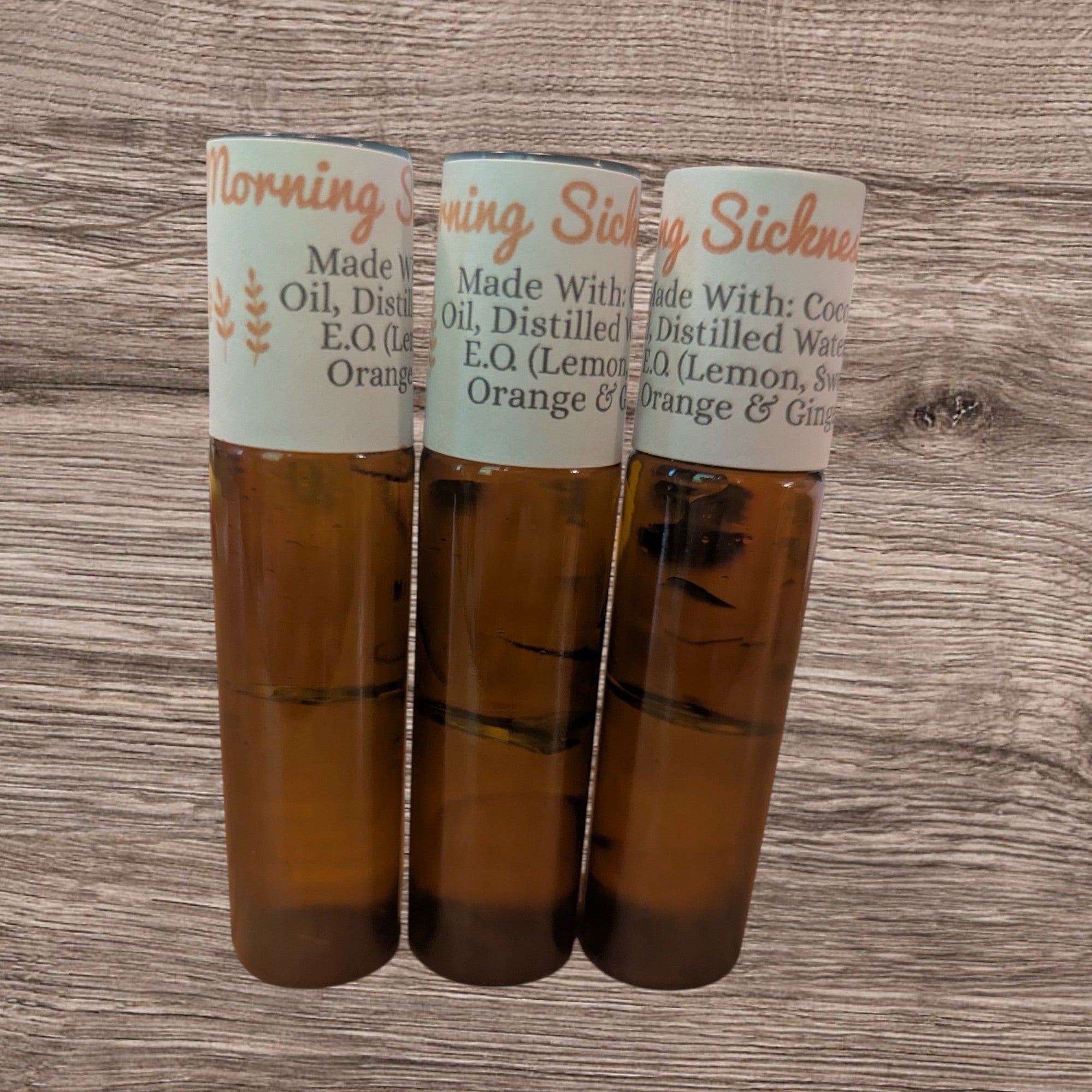 Three small bottles with labels on a wooden surface